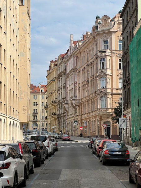 Gründerzeit street in Prague with renovated buildings and one on the right in renovation.